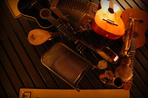 Deckenkunst im Offside Wedding: Ensemble aus mehreren Musikinstrumenten wie Gitarren und Trommeln sowie ein Schild "Swinemünder Straße"